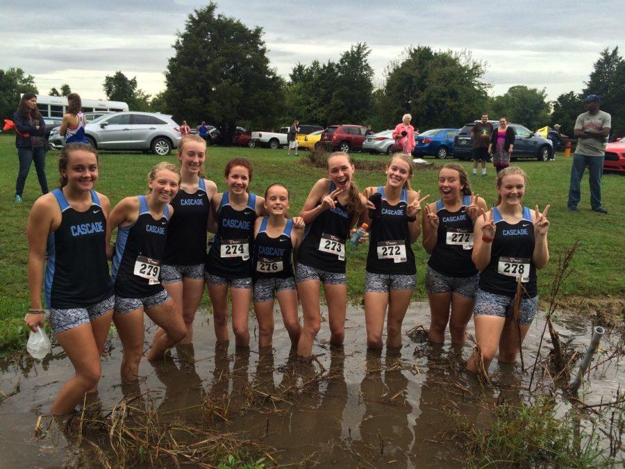 The girls cross country team wading in the puddles after the Golden Spike Invitational.