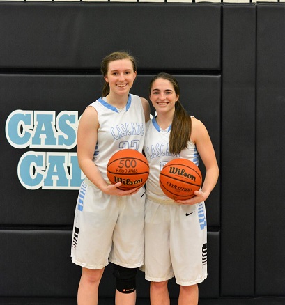 Seniors Bayleigh Walker and Makayla Collier hold the trophies from their record-breaking games.