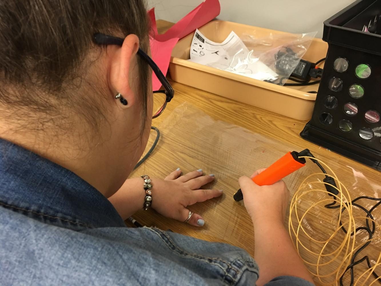 Senior Ali Beasley works with the new 3D pen in the markerspace.