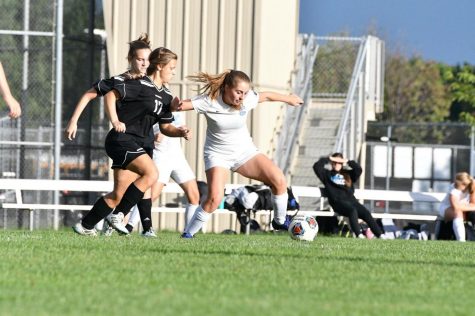 Senior Abigail Kinkle shields off a defender while moving up the pitch